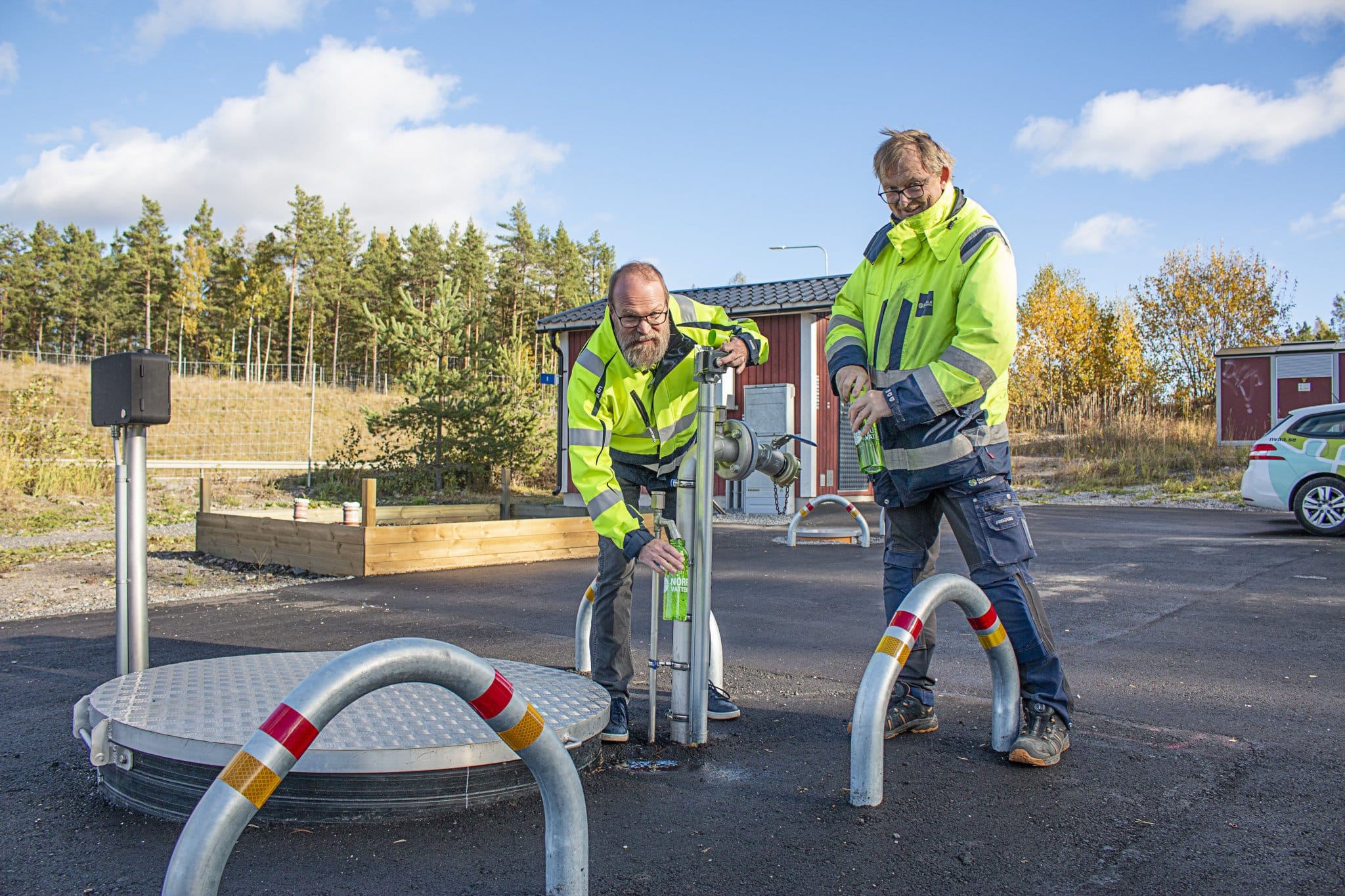 Två anställda fyller vattenflaskor i den nya vattenkiosken