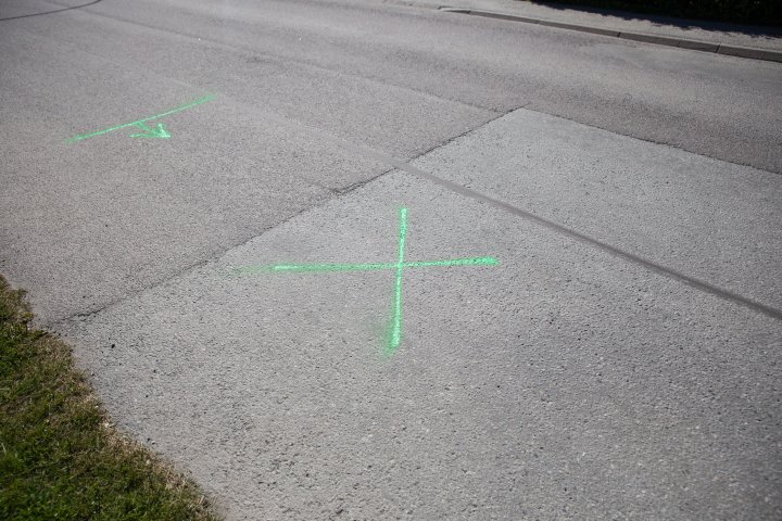 Ett sprayat kryss på asfalten