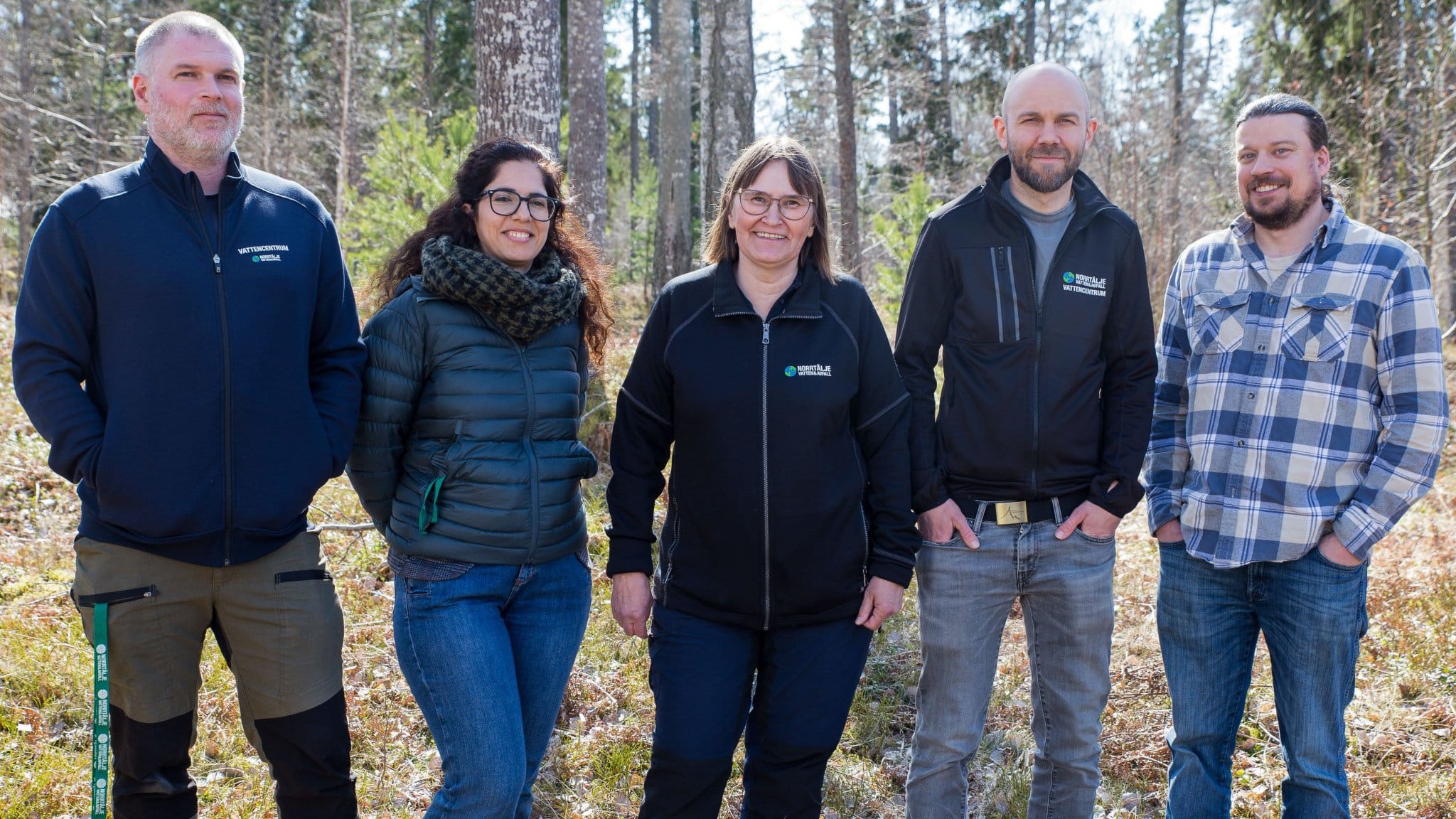 Gruppbild på vattencentrums personal med skog i bakgrunden