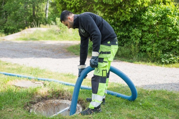 Slambilschaufför tömmer en brunn