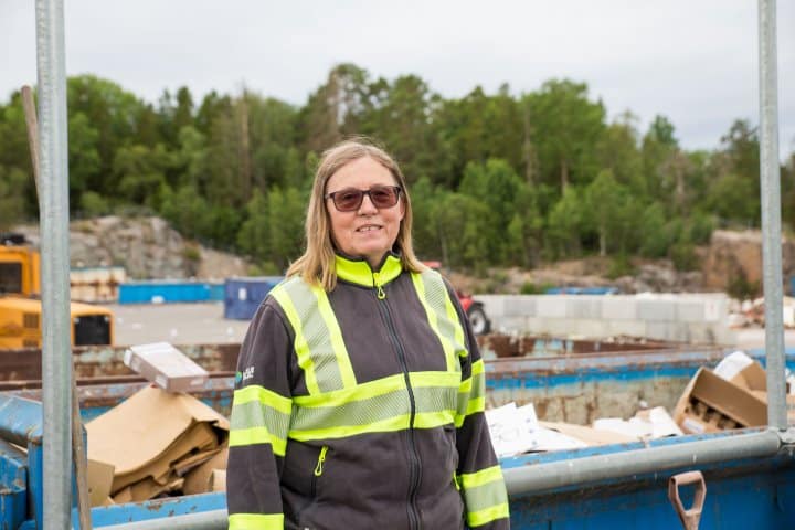 Gruppledaren Caroline står med varselkläder framför återvinningscentralen i HÄverö