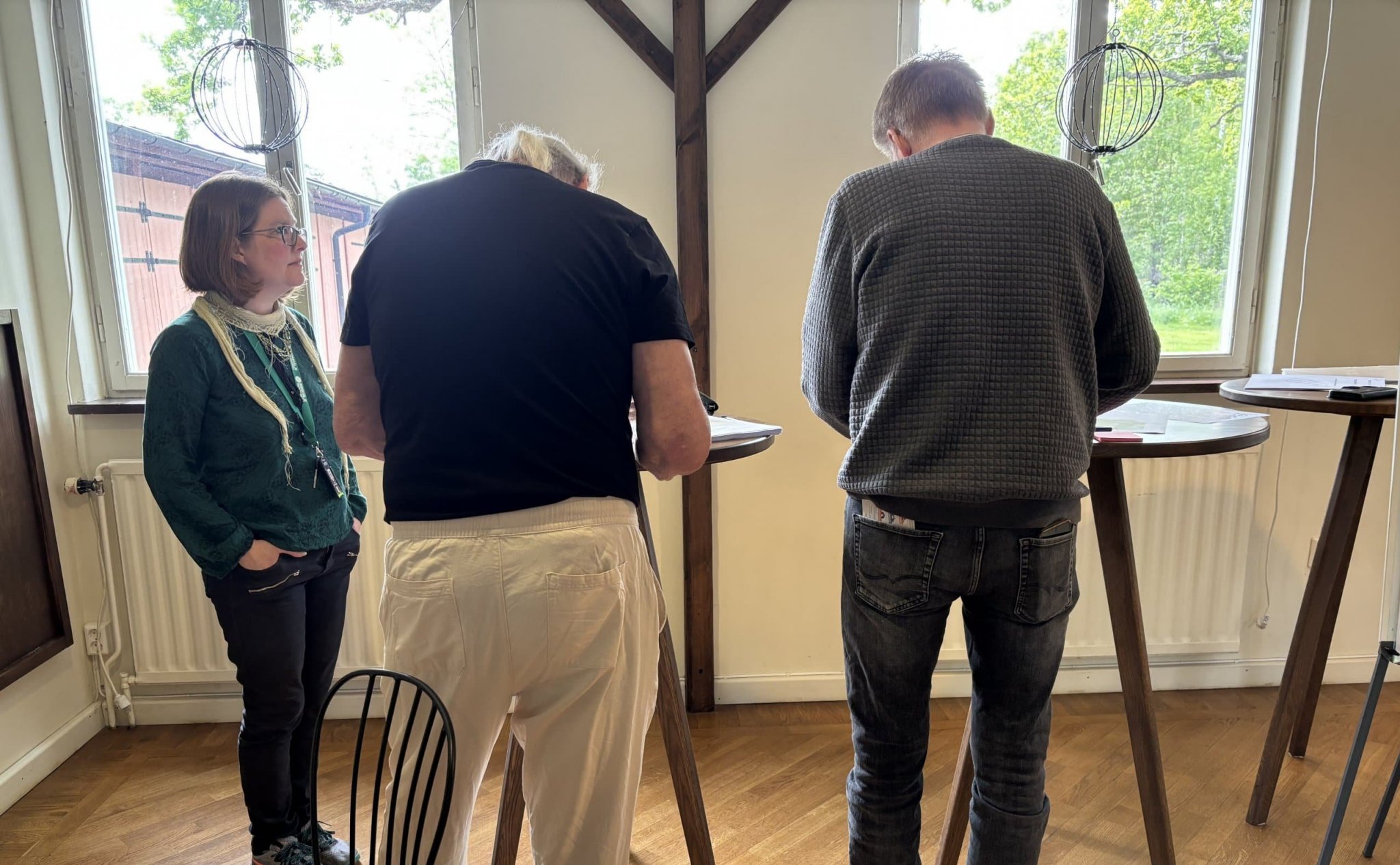 Bild på ryggen av besökare vid workshop i samtal med NVAA-anställd